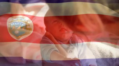 Yeni doğan bebeği Kosta Rika bayrağında sallamak ulusal gurur ve umudu sembolize ediyor. Vatanseverlik, ebeveynlik, miras, masumiyet, aile, aşk