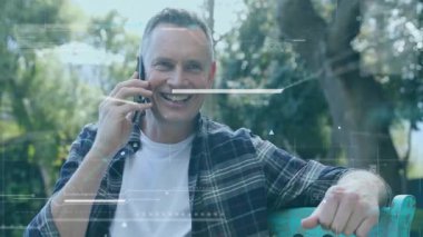 Açık havada akıllı telefon kullanarak, insan dijital arayüzle etkileşime geçip animasyon oluşturuyor. Teknoloji, yenilik, sanal, geleceksel, artırılmış gerçeklik, bağlantı