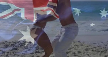 Sahilde, Avustralya bayrağı üstüste dikilmiş, animasyon sahnesiyle rahatlayan bir çift. Tatil, seyahat, tatil, rahatlama, okyanus, tatil
