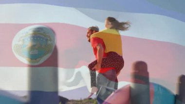 Genç çift, Kosta Rika bayrağı animasyonunu sallayarak gezintiden zevk alıyor. Tatil, ilişki, seyahat, tropik, macera, kaynaşma