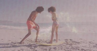 Sörf teknikleri deniyorum, kumlu sahilde okyanus manzaralı iki kişi. su sporları, macera, açık hava, dalgalar, eğlence, egzersiz