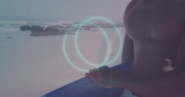 Sahilde göğsünde parlak daireler çizen tişörtsüz bir adam. Günbatımı, dalgalar, teknoloji, sanal gerçeklik, okyanus, yaz