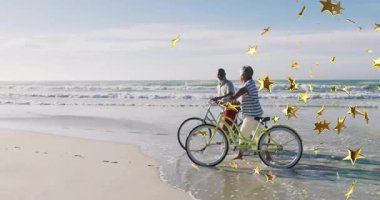 Sahilde bisiklete binen yaşlı bir çift altın yıldızlı animasyon örtüsüyle. Yaşlılar, aktif yaşam tarzı, bisiklet, romantik, animasyon, eğlence