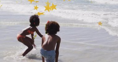 Çocuklar okyanus dalgalarında neşeyle oynuyorlar ve başlarının üstünde yıldız animasyonu var. Çocuklar, mutluluk, sahil, tatil, tatil, yaz