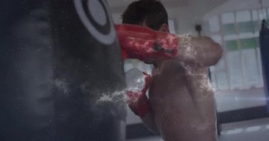 Kırmızı eldivenli boksör kozmik ışık ve toz animasyonunun üzerine kum torbası yapıştırıyor. Boks, atletizm, güç, dinamizm, dövüşçü, antrenman