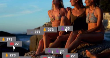 Okyanusun kenarında oturan üç kadın hakkında sosyal medya bilgilendirmeleri. Teknoloji, iletişim, plaj, birliktelik, arkadaşlık, dijital