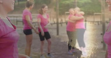 Gün batımında beşlik çakıyor, pembe tişörtlü kadınlar dışarıda kutlama yapıyorlar. Kutlama, dostluk, mutluluk, birlik, neşe, jest