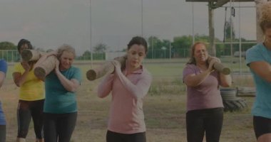 Omuzlarında kütük taşımak, dışarıda spor yapan kadınlar. Egzersiz, egzersiz, güç, dayanıklılık, takım çalışması, grup eğitimi.
