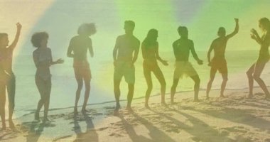 Sahilde dans eden, arka planda renkli ışık animasyonlarıyla çevrili insanlar. Parti, kutlama, gece manzarası, ışıklar, canlı, şenlikli