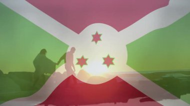 Gün batımı animasyonuna karşı Burundi bayrağını tutan siluetteki insanlar. Birlik, birliktelik, vatanseverlik, dayanışma, umut