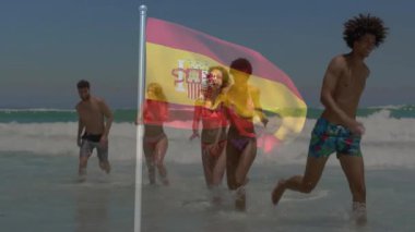 Okyanus dalgalarında koşmak, İspanyol bayrağıyla örtüşen arkadaşlar, animasyonun tadını çıkarmak. Tatil, seyahat, arkadaşlık, macera, kıyı şeridi, kültür
