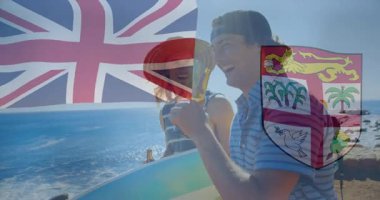 Kumsalda, erkekler Union Jack ve Fiji armalı silah animasyonlarıyla bira içiyorlardı. Tatil, gevşeme, tropikal, kutlama, eğlence, bayrak