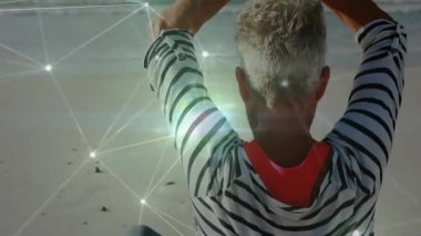 Sahilde yoga pratiği yapan, ışıldayan animasyon efektleriyle çevrili biri. Sağlık, meditasyon, zen, dinginlik, sükunet, zindelik