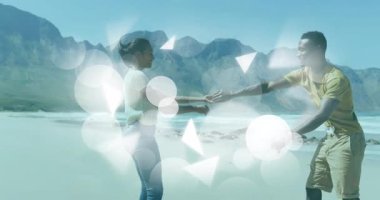 Sahilde neşeyle dans eden çift, parlak ışık animasyonlarıyla çevrili. Romantik, kutlama, aydınlanma, coşku, tatil, rahatlık