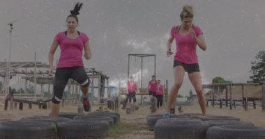 Pembe gömlekli kadınlar kozmik animasyon kaplamalı lastikler üzerinde egzersiz yapıyorlar. Spor, spor, egzersiz, takım çalışması, eğitim, gerçeküstü