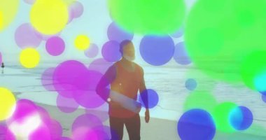 Plajda renkli kabarcık animasyon kaplamalı sörf tahtası taşıyan kişi. Sörf, okyanus, dalgalar, animasyon, canlı, yaz