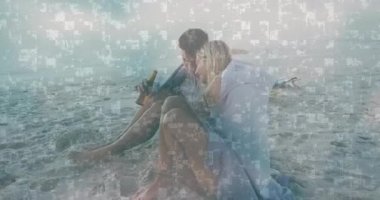 Kumsalda oturan ve dijital veri işleme animasyonu yapan çift. Teknoloji, fütürist