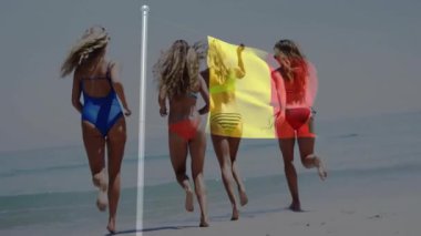 Plajda koşmak, Belçika bayrağı eşliğinde mayo giyen kadınlar. Vatanseverlik, deniz kenarı, yaz, spor