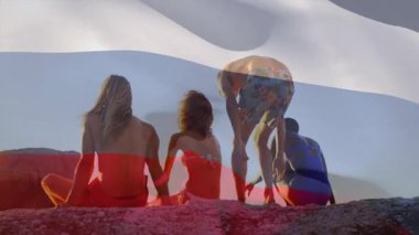 Kayaların üzerinde otururken, arka planda Rus bayrağı animasyonu olan dört kişi. Vatanseverlik, birlik, birliktelik, dostluk, seyahat, doğa