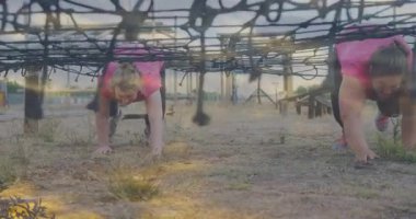 Engelli ağın altında sürünen, açık hava fitness müsabakasına katılan biri. Dayanıklılık, rekabet, macera, takım çalışması, atletik