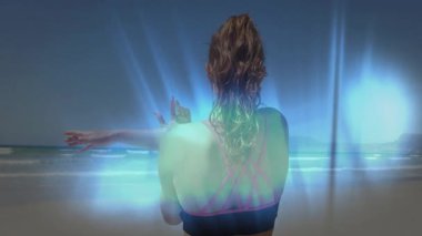 Okyanusa bakan, spor giyimli, parlak mavi aura animasyon efektli bir kadın. Sağlık, zindelik, egzersiz, meditasyon, doğa, enerji