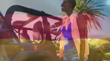 Alman bayrağı taşıyan insanlar, açık hava etkinliklerine animasyon ve şenliklerle katılıyorlar. Kutlama, kalabalık, çeşitlilik, festival, vatanseverlik, coşku