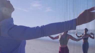 Sahilde, insanlar ön planda uzanan ellere odaklanarak yoga yapıyorlar. Sağlık, rahatlama, meditasyon, egzersiz, fitness, grup