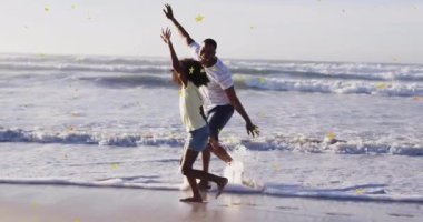 Baba ve kızı sahilde yıldız animasyonu eşliğinde neşeyle oynuyorlar. Aile, bağ, mutluluk, deniz kenarı, eğlence, yaz zamanı