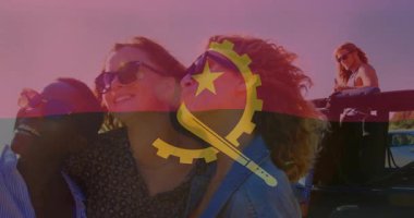 Angola bayrağıyla gülümseyen arkadaşlar kumsalda birlikte animasyonun tadını çıkarıyorlar. Seyahat, tatil, arkadaşlık, eğlence, çok kültürlü, grup