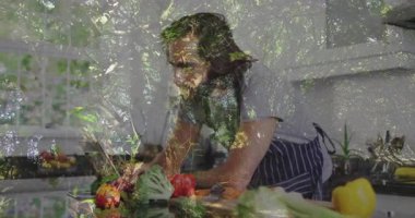 Mutfakta sebze hazırlayan, ağaç dallarının animasyonu olan bir adam. Yemek pişirme, aşçılık, sağlıklı beslenme, hazırlık, yaratıcılık, botanik