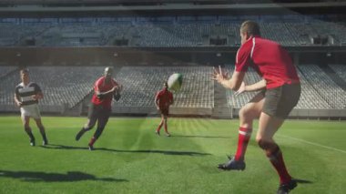 Sahada, rugby oyuncuları stadyumun arka planıyla mücadele ederek yoğun bir animasyon yaratıyorlar. Spor, atletizm, rekabet, takım çalışması, aksiyon, yoğunluk