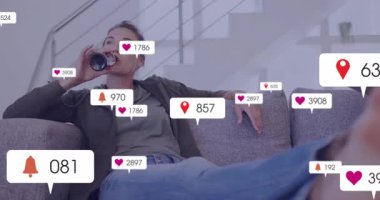 Kanepede dinlenen, sosyal medya bildirimlerini alan kişi. Teknoloji, rahatlama, akıllı telefon, iletişim, yaşam tarzı, dijital