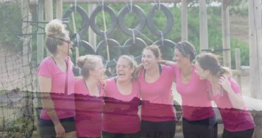 Birlikte gülüyorlar, pembe tişörtlü kadınlar açık hava engelli parkurunda dans ediyorlar. Takım çalışması, macera, meydan okuma, koşu, rekabet, açık hava