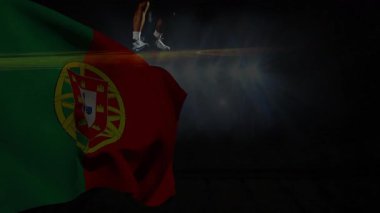 Dramatik ışıklandırmada, Portekiz bayrağı üzerinde animasyon etkisiyle gösteri yapan bir atlet. Spor, ulusal, performans, yarışma