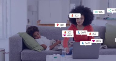 Sosyal medya tebligatlarıyla dizüstü bilgisayar kullanan, kanepenin üzerinde dinlenen bir kadın. Teknoloji, çoklu görev, dijital, ebeveynlik, rahatlama, yaşam tarzı