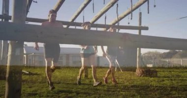 Engelli koşu parkurunda, sporcular dışarıda halat ve tahta kirişler kullanıyor. Macera, takım çalışması, fitness, meydan okuma, dayanıklılık, güç