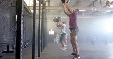 Spor salonunda, insanlar etrafta yüzen başparmak kaldırma simgeleriyle egzersiz yapıyorlar. Fitness, egzersiz, motivasyon, onay, dijital