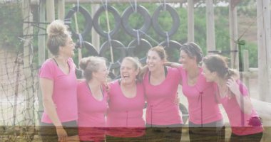 Engel parkurunda birlikte gülen pembe tişörtlü kadınlar animasyondan zevk alıyorlar. Takım çalışması, bağ, fitness, macera, meydan okuma, açık hava