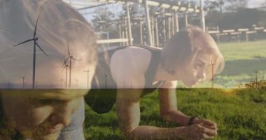 Yeşil manzara animasyonu üzerinde rüzgar türbinleriyle dışarıda egzersiz yapan bir kadın. Yenilenebilir, sürdürülebilir, enerji, uygunluk, çevre