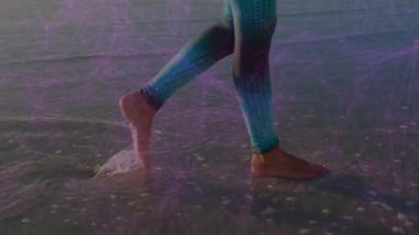 Kumsalda yürümek, dijital ağın animasyonuyla desenli tozluklarla bacaklar. Teknoloji, fitness, aktif giyim, bağlantı, fütüristik, yenilik