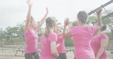 Takım çalışmasını kutluyoruz, pembe tişörtlü kadınlar açık hava engelli parkurunu birlikte tamamlıyorlar. işbirliği, güçlendirme, meydan okuma, fitness, başarı, yarış