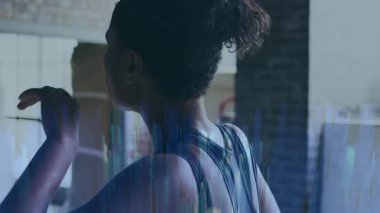 Spor yaptıktan sonra dinlenen, spor salonunda dijital veri üst üste binen bir kadın. Fitness, technology, exercise, analysis, futuristic, health