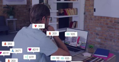 Dizüstü bilgisayardan animasyon izlemek, evde sosyal medya tebligatı almak. Teknoloji, çoklu görev, eğlence, iletişim, dijital cihaz, ev ofisi