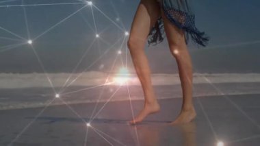 Kumsalda yürürken, çevrende parıldayan ağ animasyon bağlantıları olan biri. Teknoloji, dijital, ağ, fütüristik, bağlantı, siber uzay