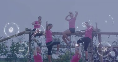 Engel parkuruna tırmanan, pembe tişörtlü, dijital simgeli kadınlar. Takım çalışması, meydan okuma, macera, fitness, teknoloji, işbirliği