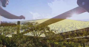 Ahşap engellere tırmanmak, ağaçlar ve tarlalarla manzaralı manzaranın üzerindeki insan. Macera, açık hava, doğa, keşif, yürüyüş, meydan okuma