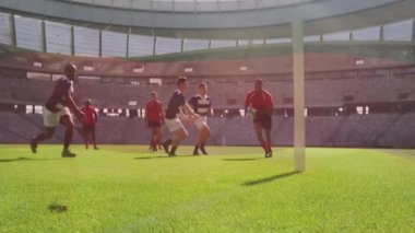 Top yakalamak için dalan, kırmızı üniformalı ragbi oyuncusu stadyumda. Spor, atlet, yarışma, takım çalışması, aksiyon, atletik