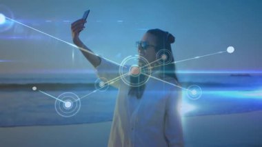 Sahilde selfie çeken, dijital ağ bağlantıları olan bir kadın. Teknoloji, ağ kurma, tatil, yaz, boş zaman