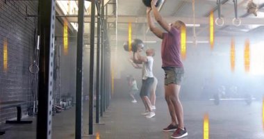 Spor salonunda ilaç toplarıyla egzersiz yapmak, endüstriyel ışıklandırma altındaki insanlar. Spor, spor, güç, egzersiz, spor, eğitim