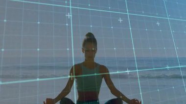 Sahilde meditasyon yapan bir kadın dijital şebeke ile sahneyi örtüyor. Meditasyon, teknoloji, sükunet